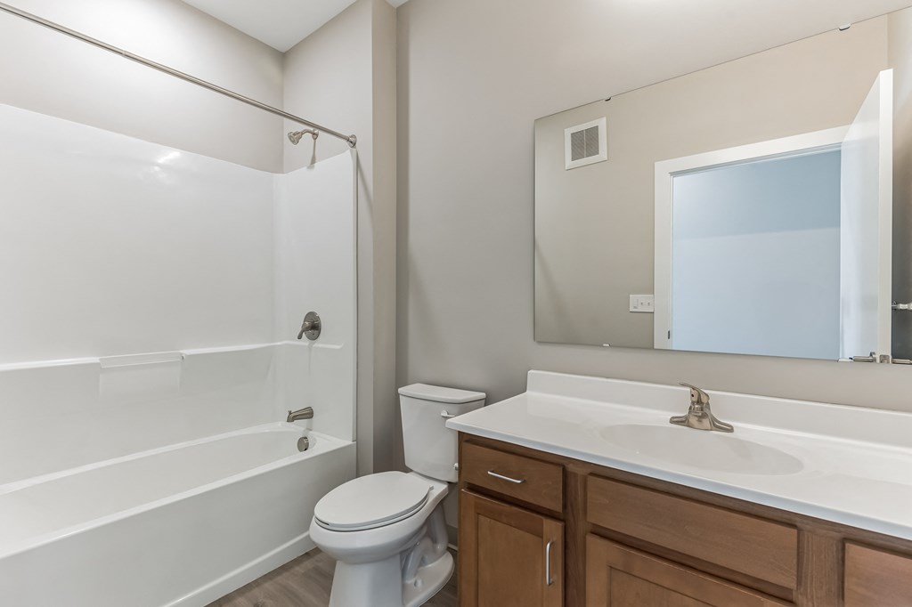 a bathroom with a shower toilet and sink and a mirror