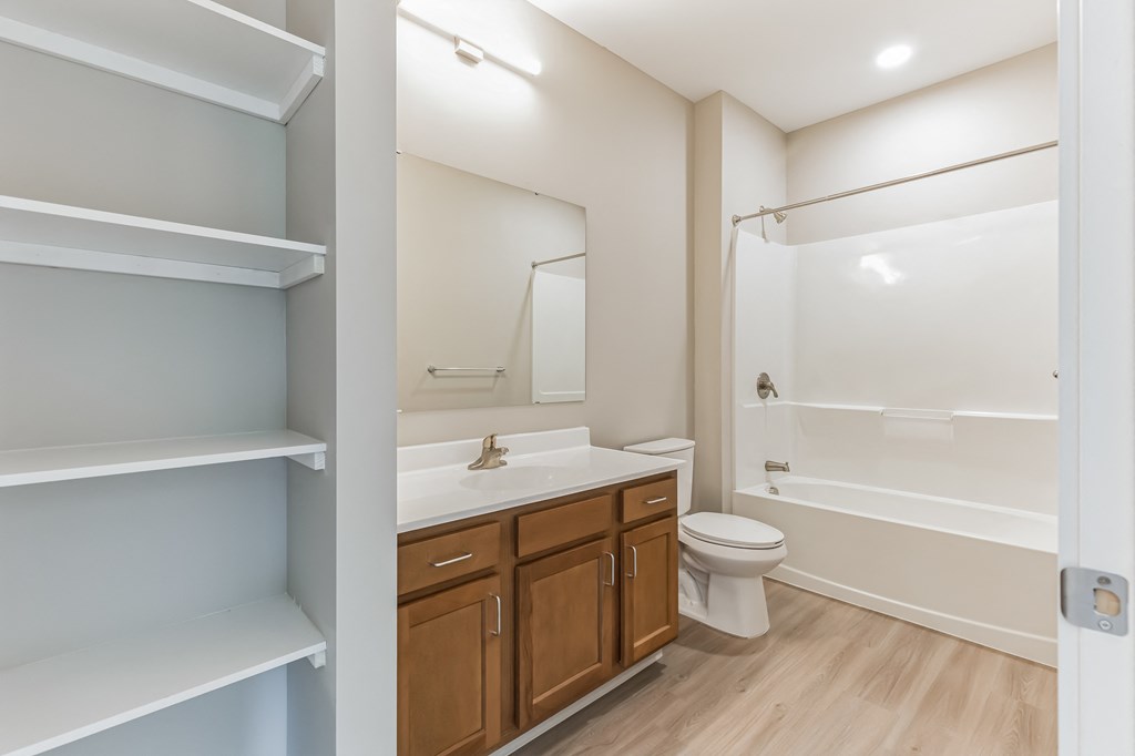 a bathroom with a toilet sink and shower and a mirror