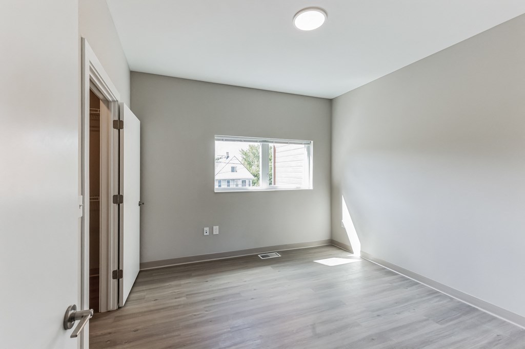 an empty room with white walls and a window