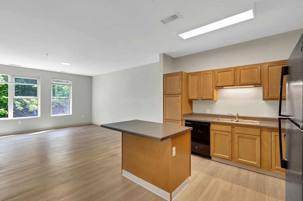 an empty kitchen with wood floors and wooden cabinets