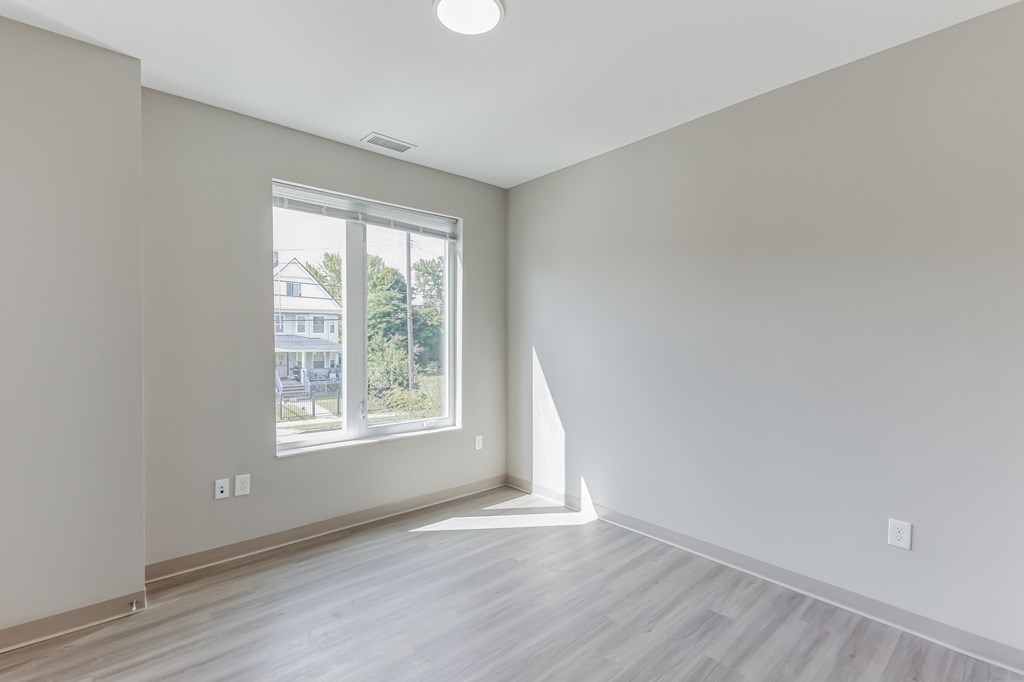 an empty room with white walls and a window