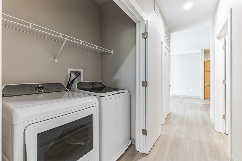 a laundry room with two washes and a dryer in a house
