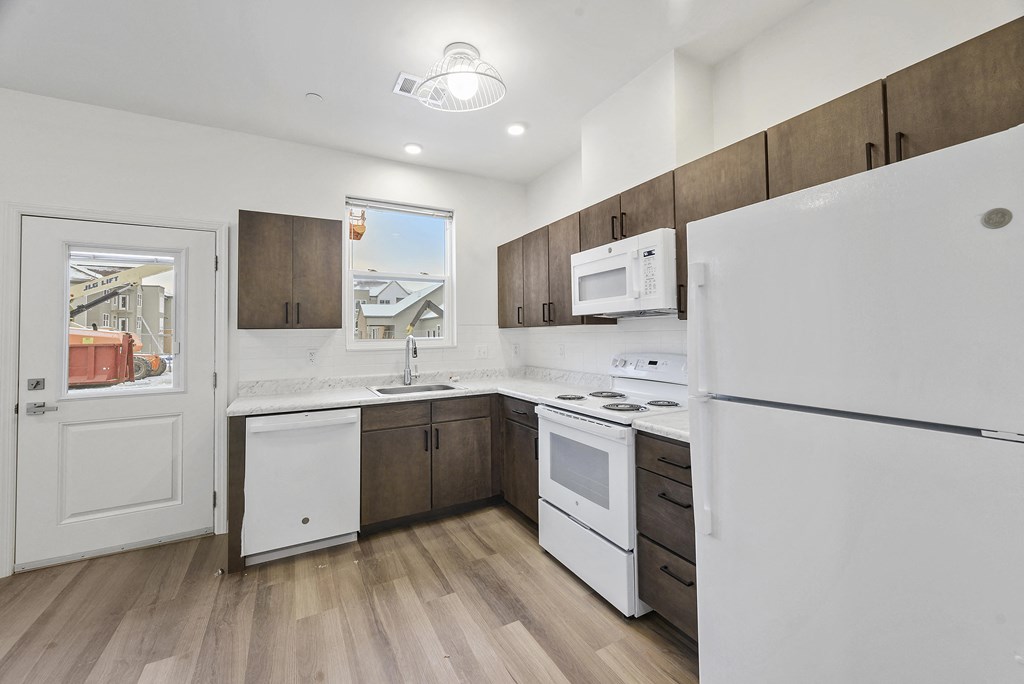 a kitchen with white appliances and wooden cabinets and a white refrigerator