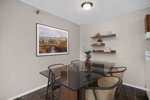 A dining room with a glass table and chairs.