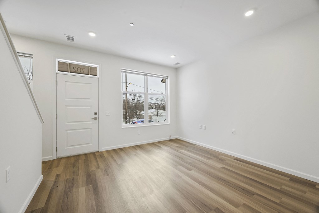 a living room with white walls and a window and a door