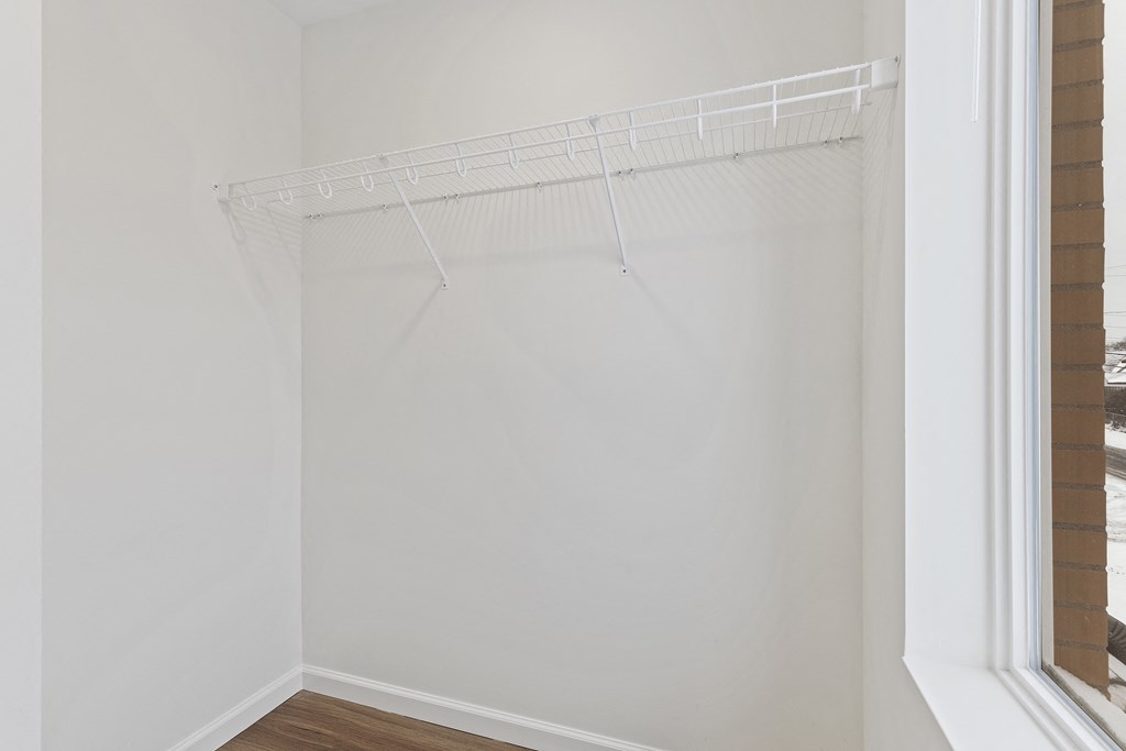 an empty closet with a white wall and a window