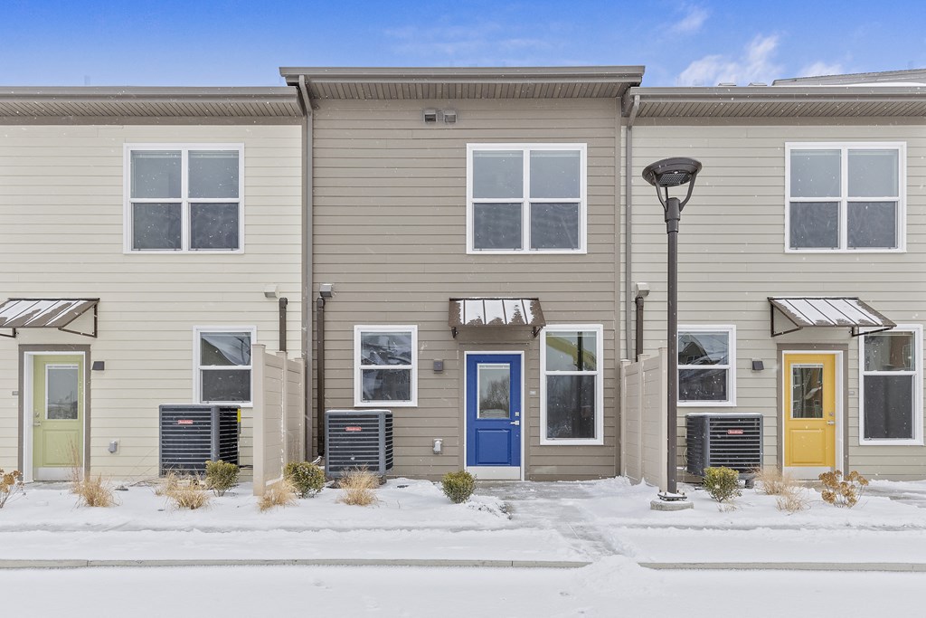 a building with a blue door and a snow covered sidewalk