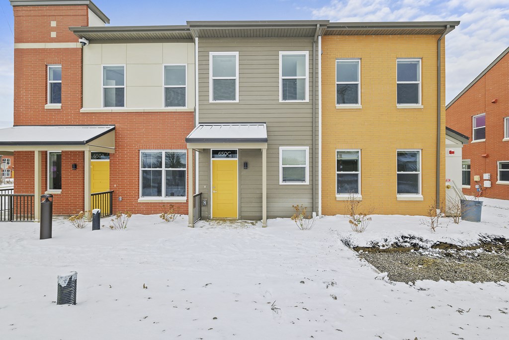 a house with yellow doors in the snow