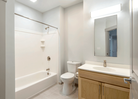 A white bathroom with a toilet, sink, and bathtub.