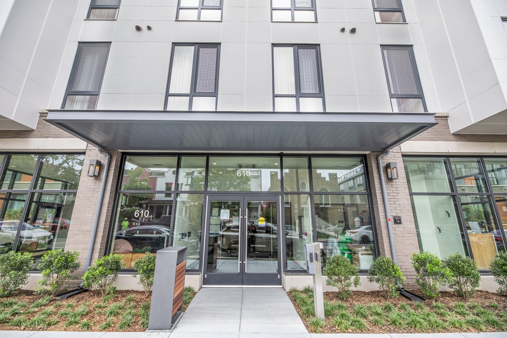 A modern building with a glass entrance and a brick pillar.