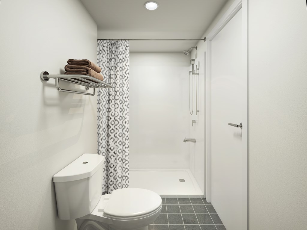 A white toilet with a towel on a towel rack in a bathroom.