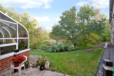 A patio with a table and chairs overlooks a garden.