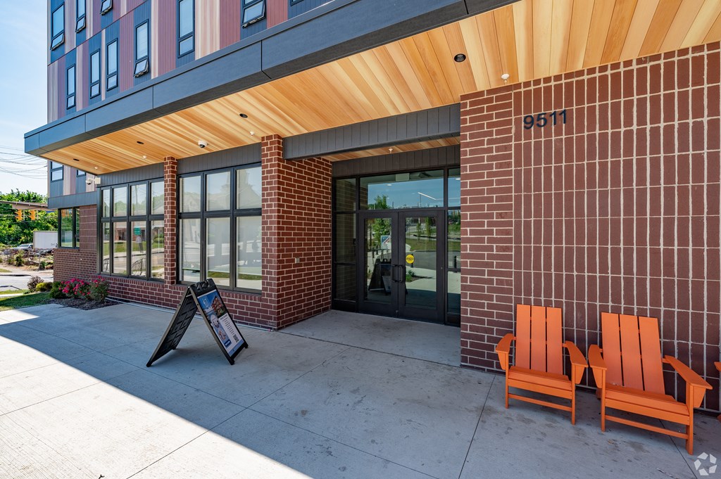 the lobb lobby of a building with two orange chairs and a sign