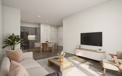A modern living room with a grey sofa, a wooden coffee table, and a television on a white cabinet.