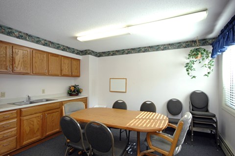 A conference room with a table, chairs, and a plant.