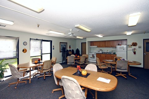 A conference room with a table surrounded by chairs.