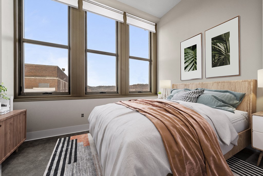 a bedroom with a bed and three windows