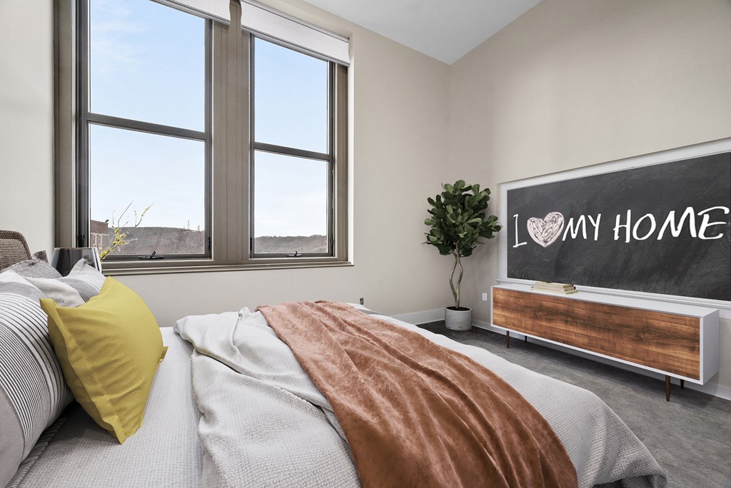 an empty bedroom with a bed and a chalkboard on the wall