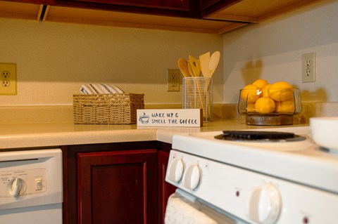 A kitchen with a white stove and a basket on the counter.