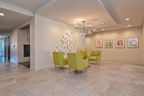 A living room with a yellow chair and a white Christmas tree.