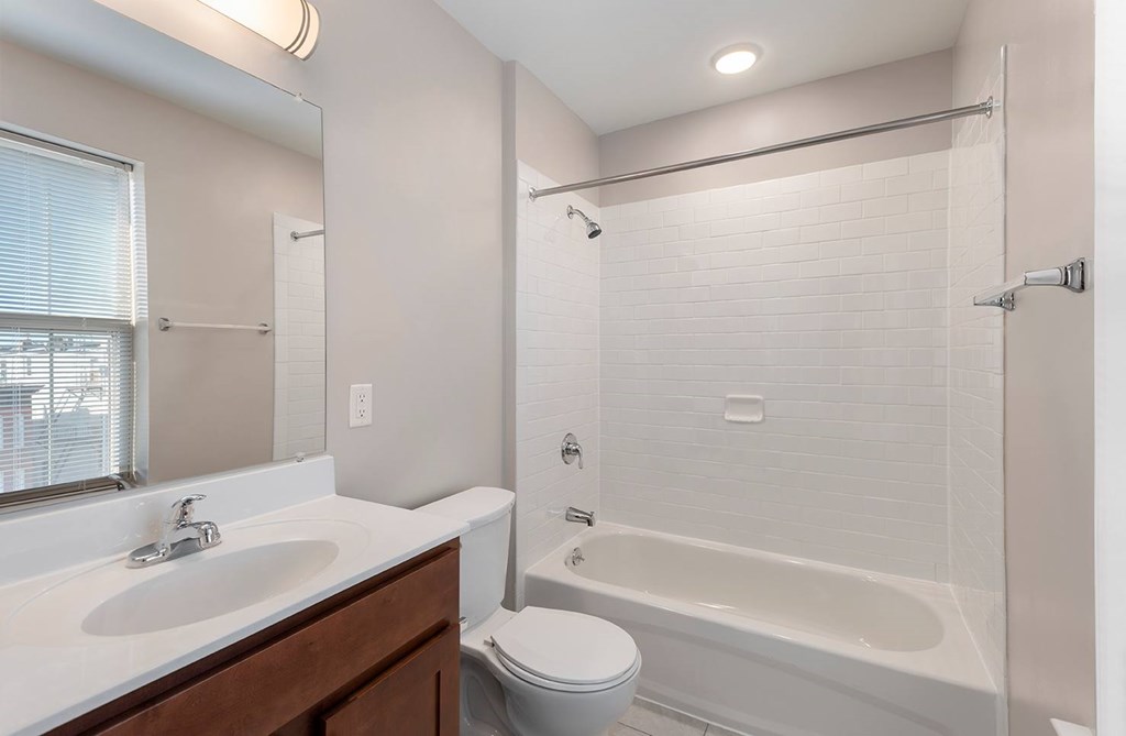 A white bathroom with a toilet, sink, and bathtub.