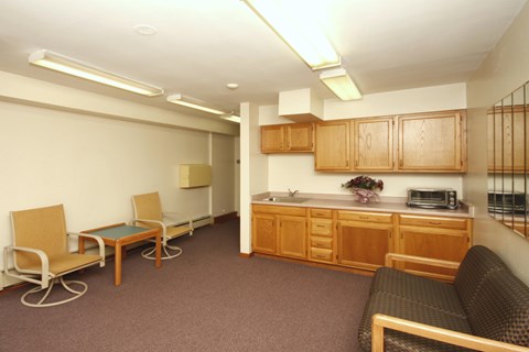 A living room with a brown couch and a wooden table.