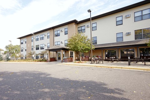 Apartment building with a parking lot in front.