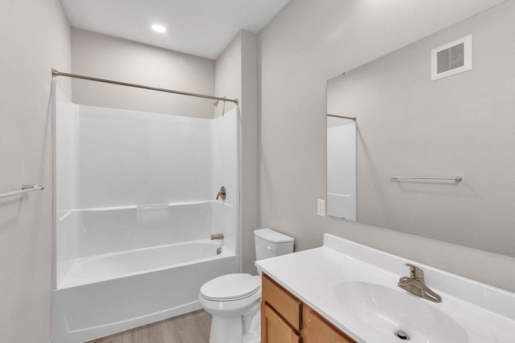 an empty bathroom with a shower toilet and sink