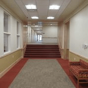 A long hallway with a staircase and a bench.