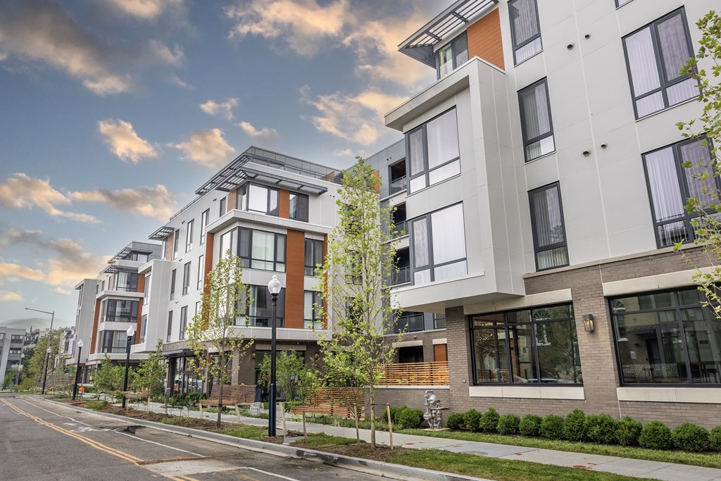 A modern apartment building with a mix of white and brown exterior walls.