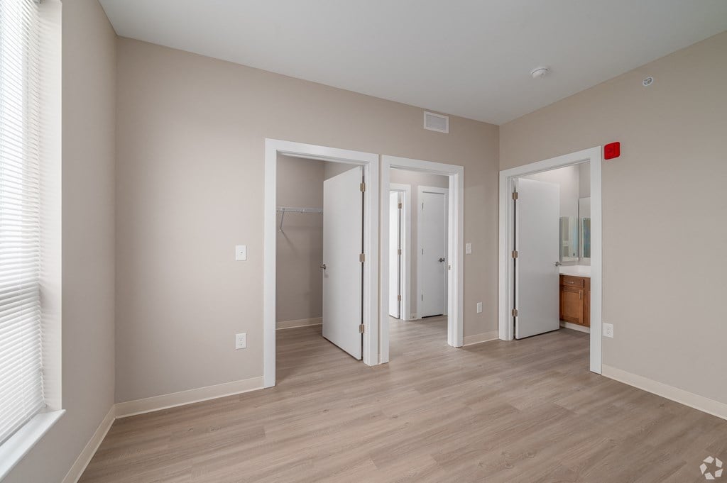 a living room with a hard wood floor and a door to a bathroom