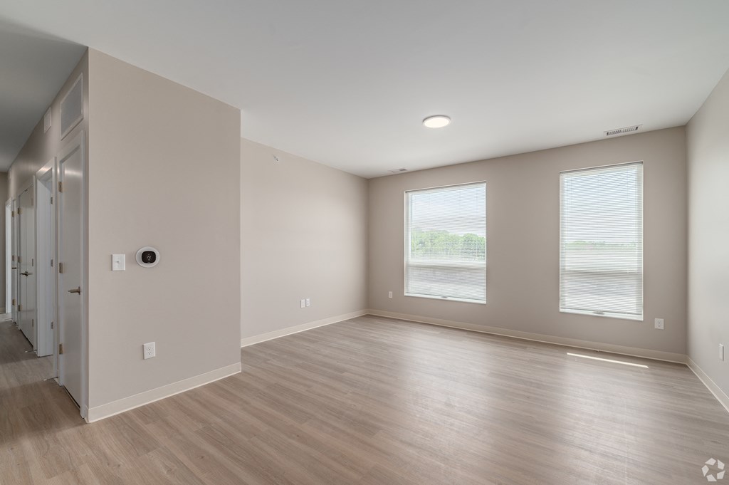 a living room with a hard wood floor and a large window