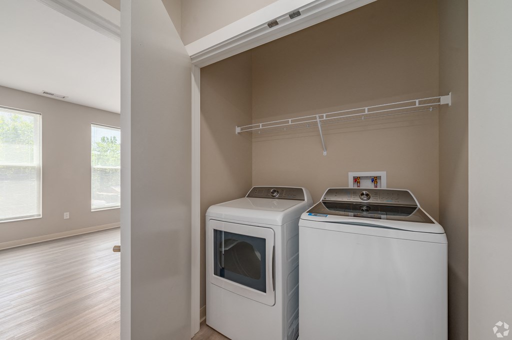 an empty laundry room with two washes and a dryer in it