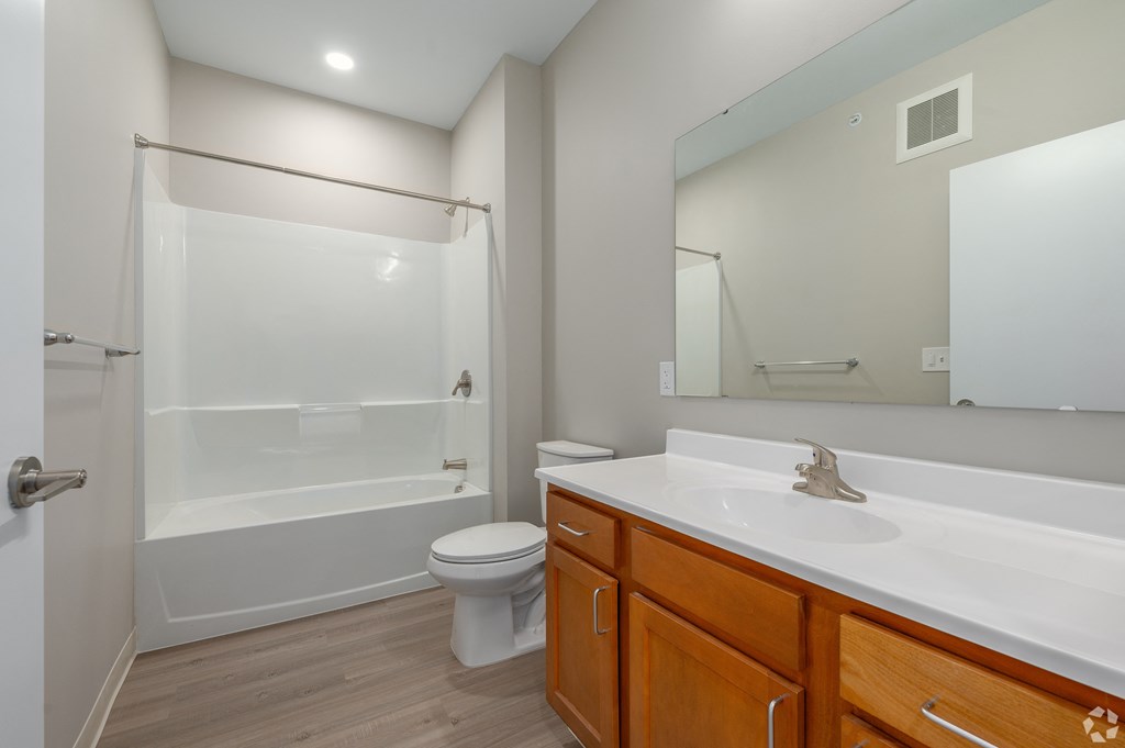 a bathroom with a large mirror and a shower and a sink
