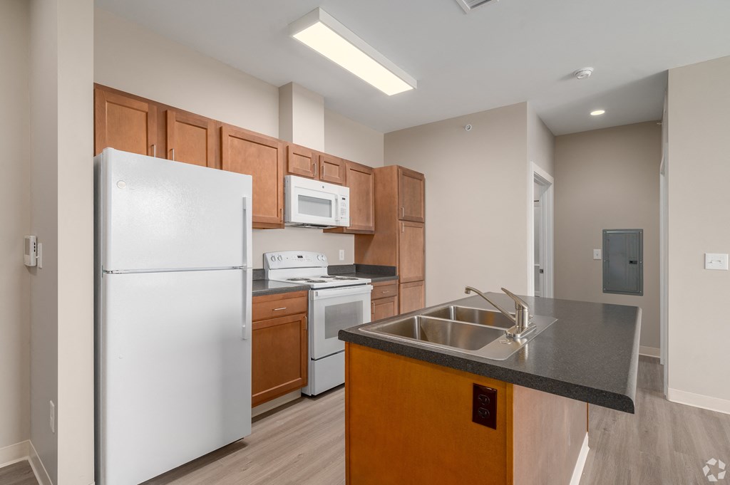 a kitchen with white appliances and wooden cabinets and a stainless steel counter top