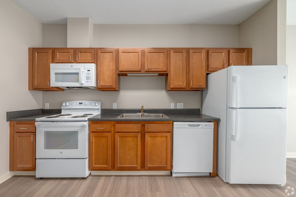 a kitchen with white appliances and wooden cabinets