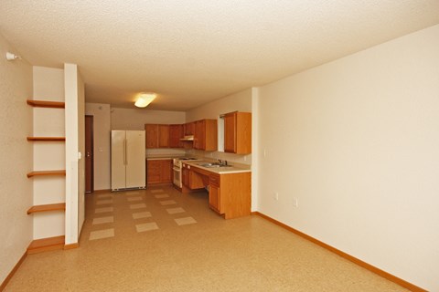 A kitchen with wooden cabinets and a refrigerator.