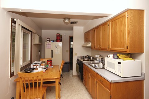 A kitchen with wooden cabinets and a table.