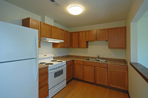 A kitchen with wooden cabinets and a white refrigerator.