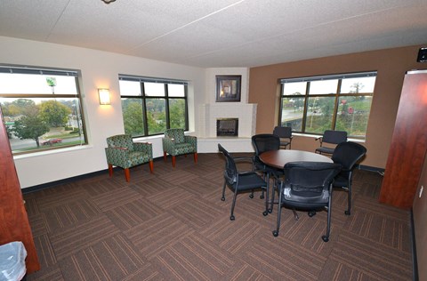 A conference room with a fireplace and a view of the outside.