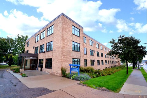 A red brick building with a blue sign in front.