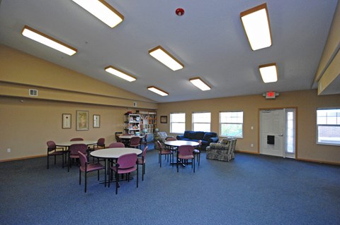 A room with tables and chairs and a fire extinguisher on the ceiling.