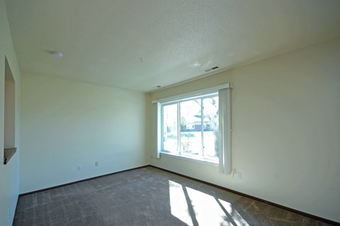 A room with a window and a grey floor.