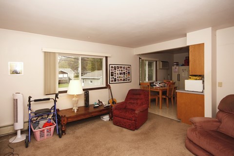 A living room with a red chair and a wooden bench.