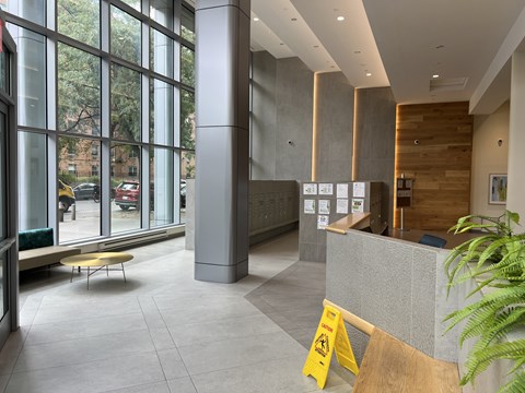 A yellow caution sign is in front of a grey reception desk.