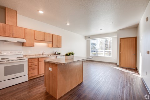 A kitchen with wooden cabinets and a white stove top oven.