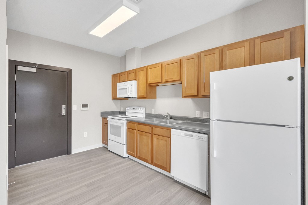 a kitchen with white appliances and wooden cabinets and a refrigerator