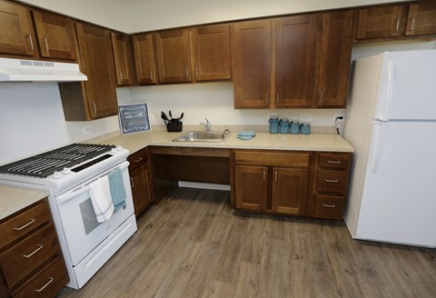 A kitchen with wooden cabinets and a white refrigerator.