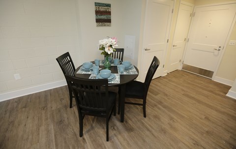 A dining table with chairs and a vase of flowers.