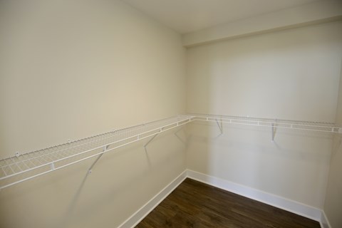 Empty room with white walls and wooden floor.